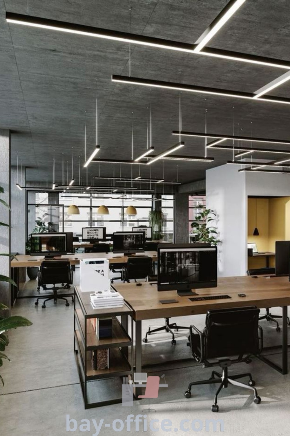 An empty office loft design with multiple desks and plants, showcasing a stylish and productive work environment. Perfect for cozy aesthetics, inspiring productivity, and modern design trends for small office spaces. Learn more at bay-office.com.