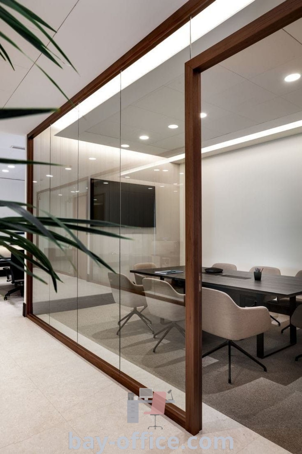 Modern conference room featuring glass walls, plants, and a contemporary design, showcasing decor ideas for small spaces and office table design for enhanced productivity. Explore modern office design inspiration at bay-office.com.