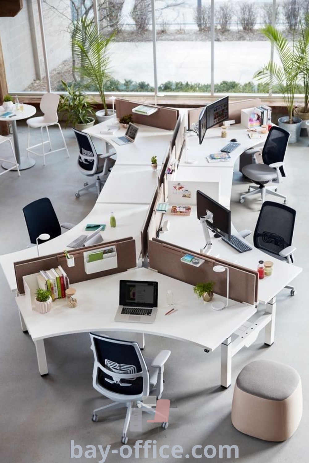 An office cubicle featuring multiple desks and chairs in the center, with two computers, showcasing creative office design ideas that inspire productivity and collaboration. Discover more on bay-office.com.