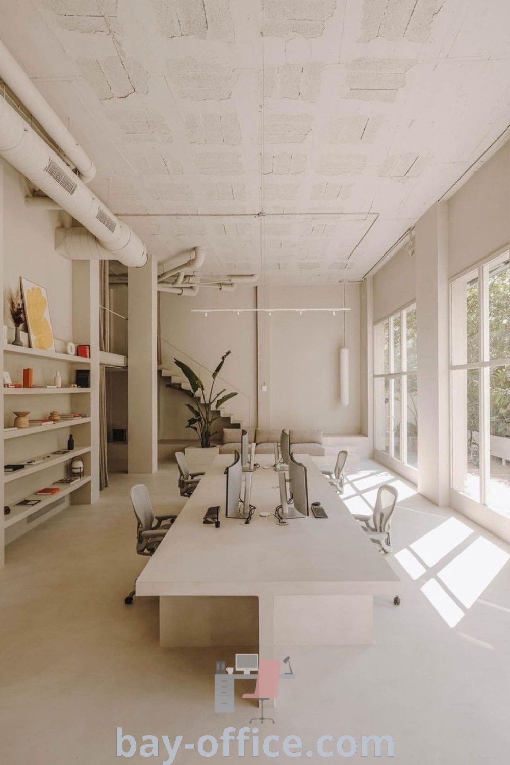 Open office space with white walls and flooring, featuring concrete effect paint, designed for productivity and a calming aesthetic. Discover decorating ideas that inspire productivity and create an inviting workspace at bay-office.com.