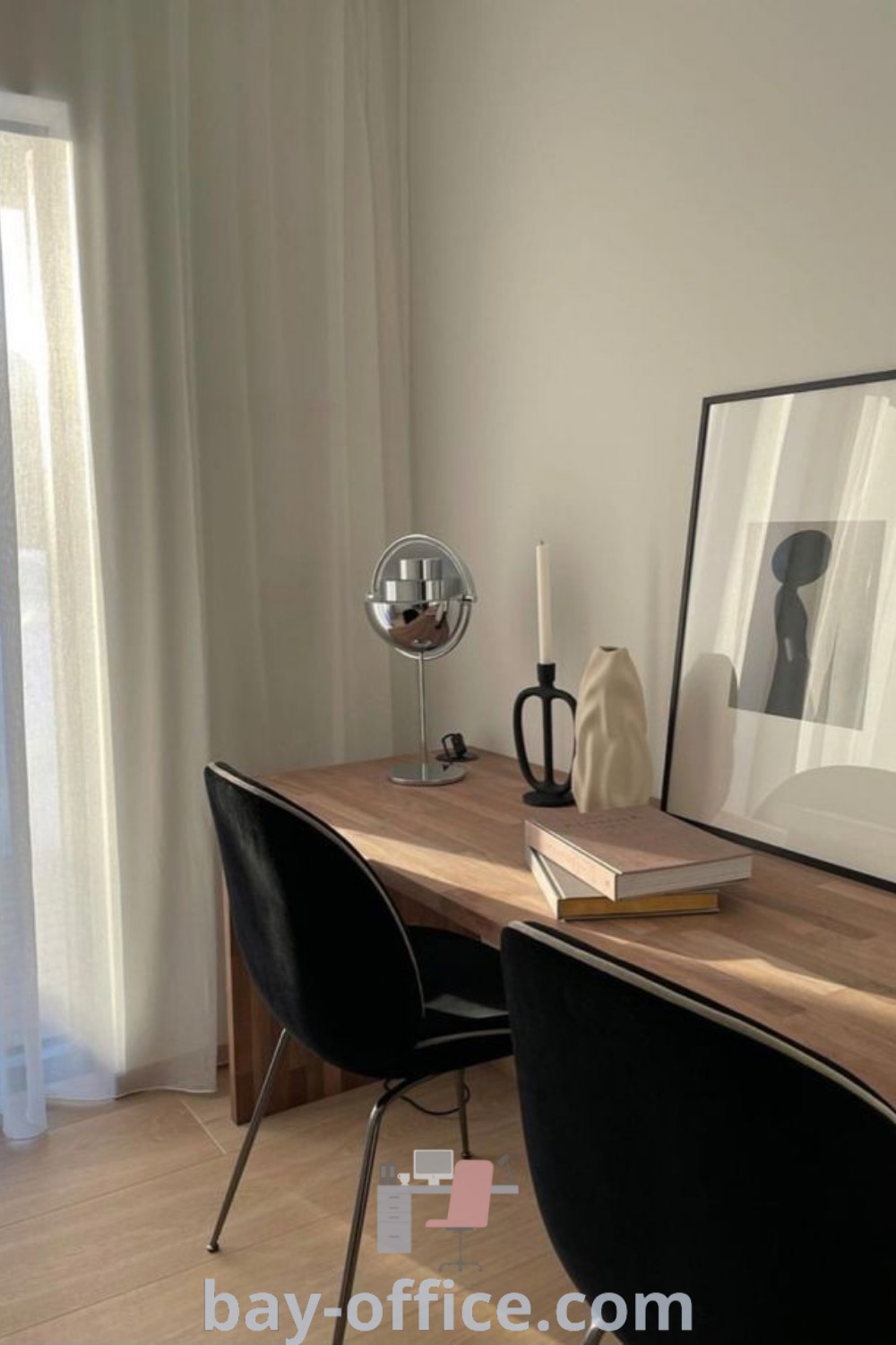 Elegant desk setup with mirror, two chairs, and a framed photograph in a cozy beige and black office. Ideal design tips for small spaces. Explore more decorating ideas for inspiring and functional home offices at bay-office.com.