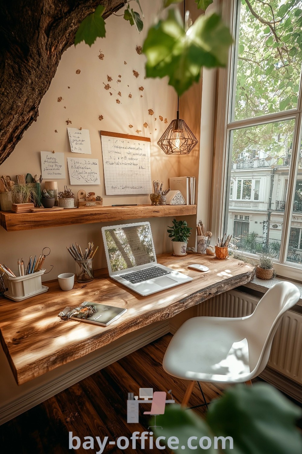A laptop computer on a wooden desk next to a tree by a window, showcasing cozy home office ideas perfect for productivity and aesthetic appeal. Explore inspiring decor ideas and stylish office tips at bay-office.com.