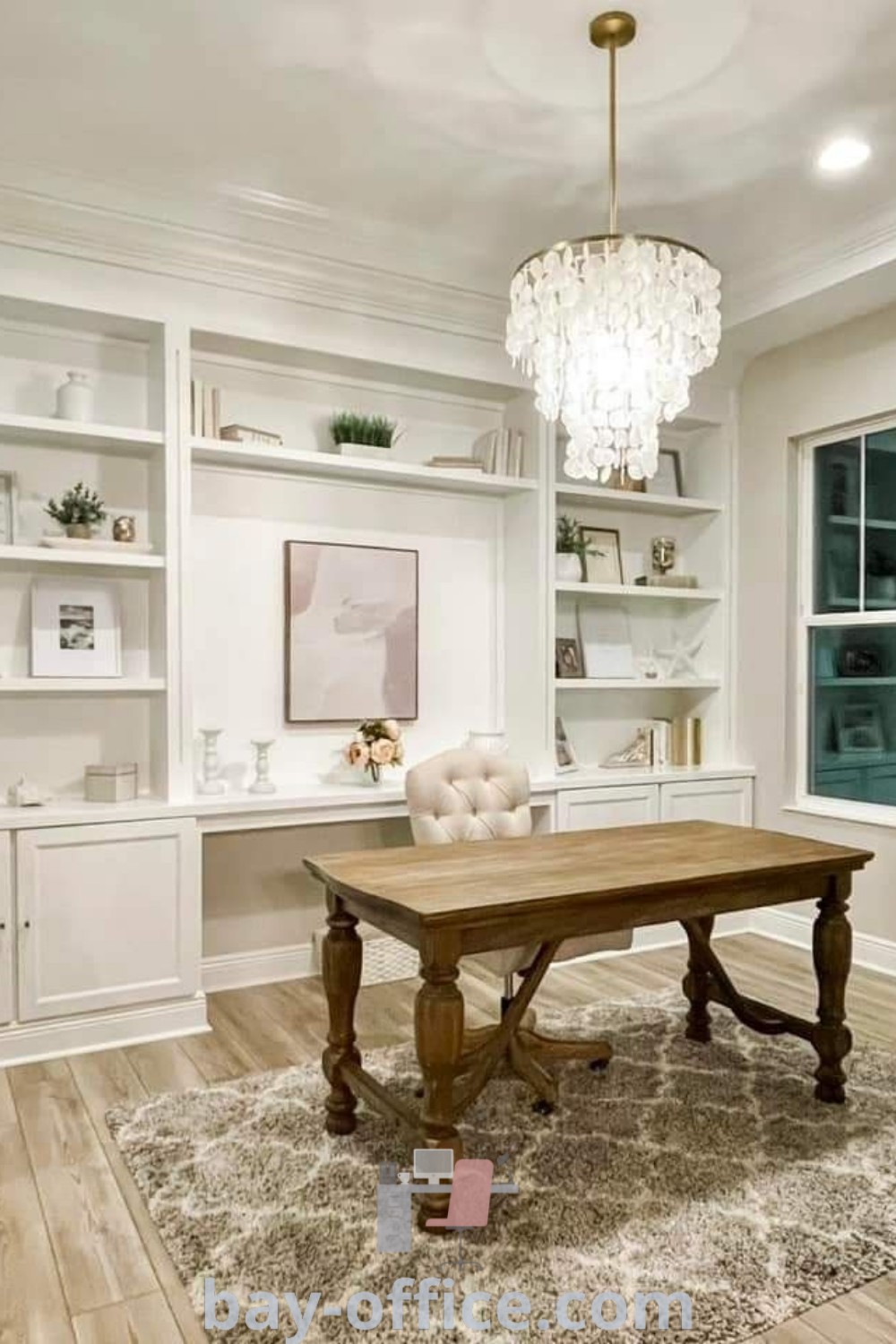 Elegant neutral office with built-in bookcases and white decor, featuring a chandelier above, showcasing a small office layout with two desks. Perfect for inspiring productivity and cozy aesthetics. Explore design trends and decor ideas for small spaces at bay-office.com.