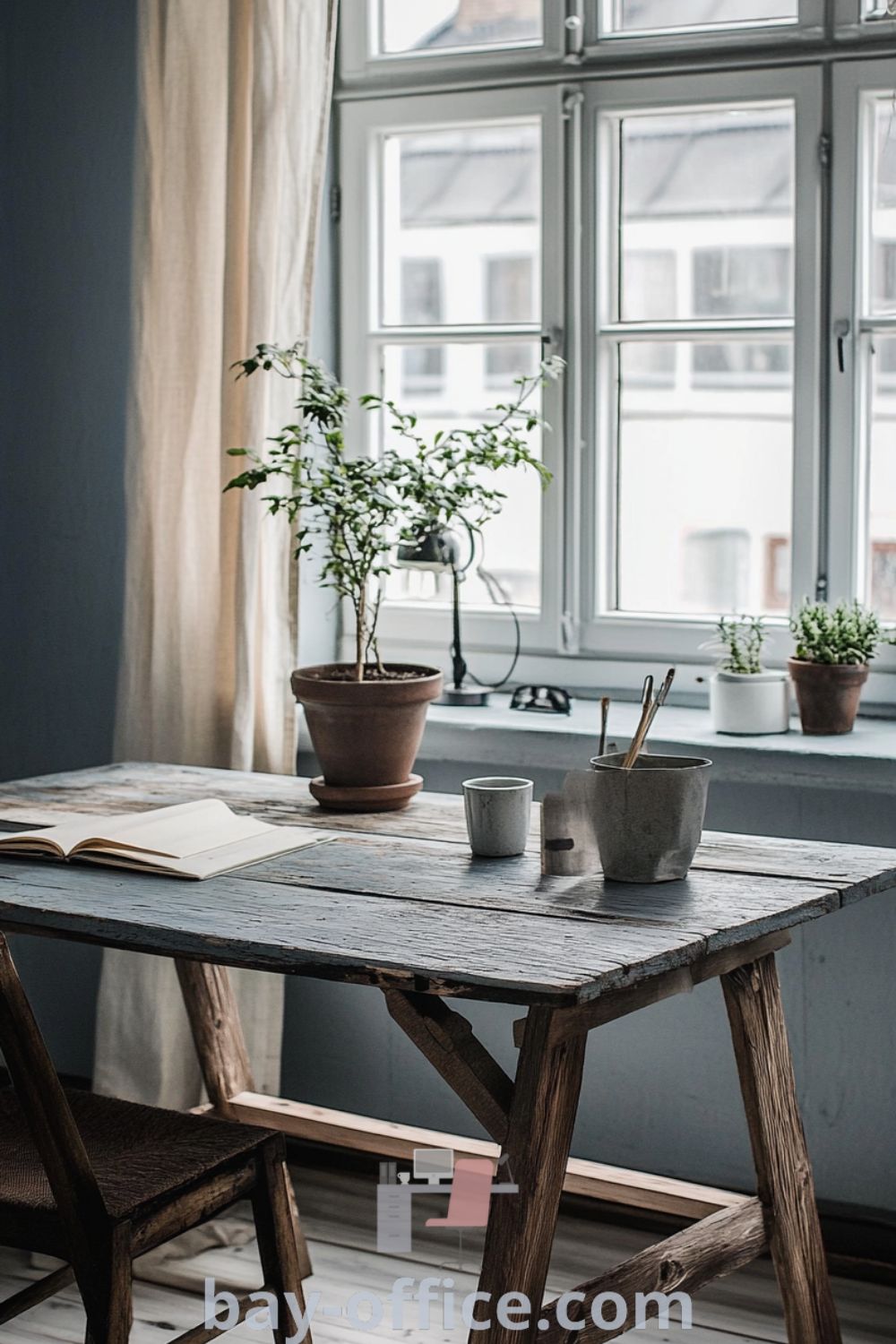 Scandinavian home office with serene blue walls, large windows, a weathered wooden desk, and potted plants, showcasing cozy design elements that inspire productivity and create a calming atmosphere. Explore more design ideas at bay-office.com.
