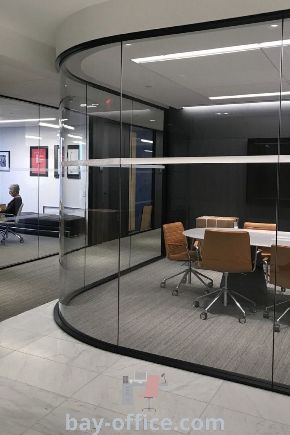 Modern office meeting room with glass walls, round conference table, and stylish chairs, showcasing office flooring ideas and modern workspace design. Discover inspiring conference room decor ideas at bay-office.com.