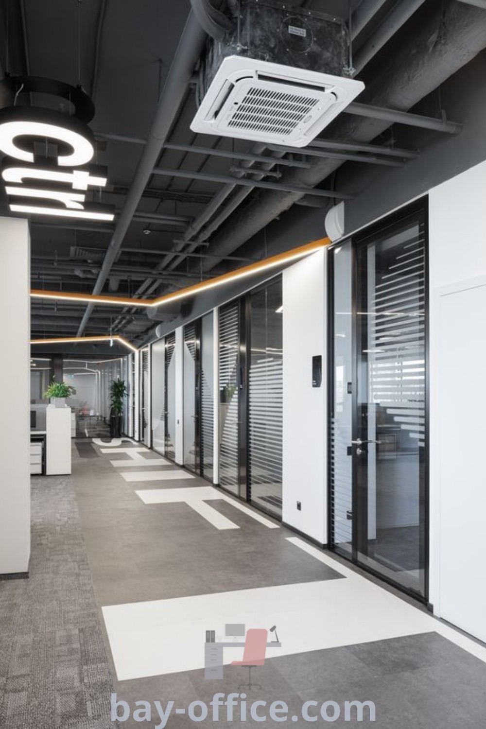 An empty industrial office building with large windows, mesh ceiling, and corridor wall designs showcasing modern aesthetics. Ideal for creating a productive workspace that inspires creativity. Explore more design tips and ideas you need to see at bay-office.com.